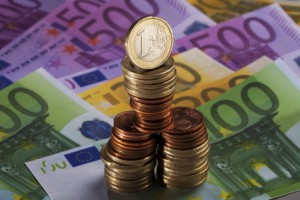 Münzstapel stehen auf Euro Scheinen